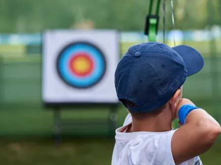 Boy shooting a bow for accuracy