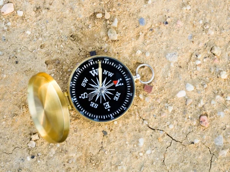 Golden compass on sandy ground