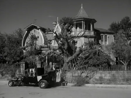 The Munsters Beside the Munster Koach on the Street in Front of Their House