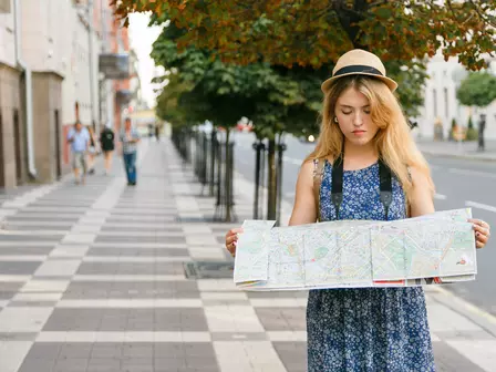 a woman looking at a map in a foreign city