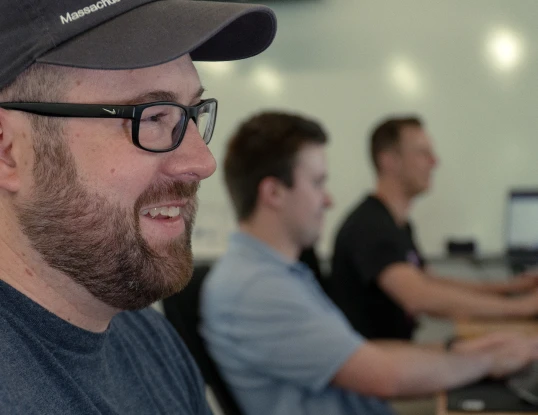 Three support reps, focused on the closest. All smiling.